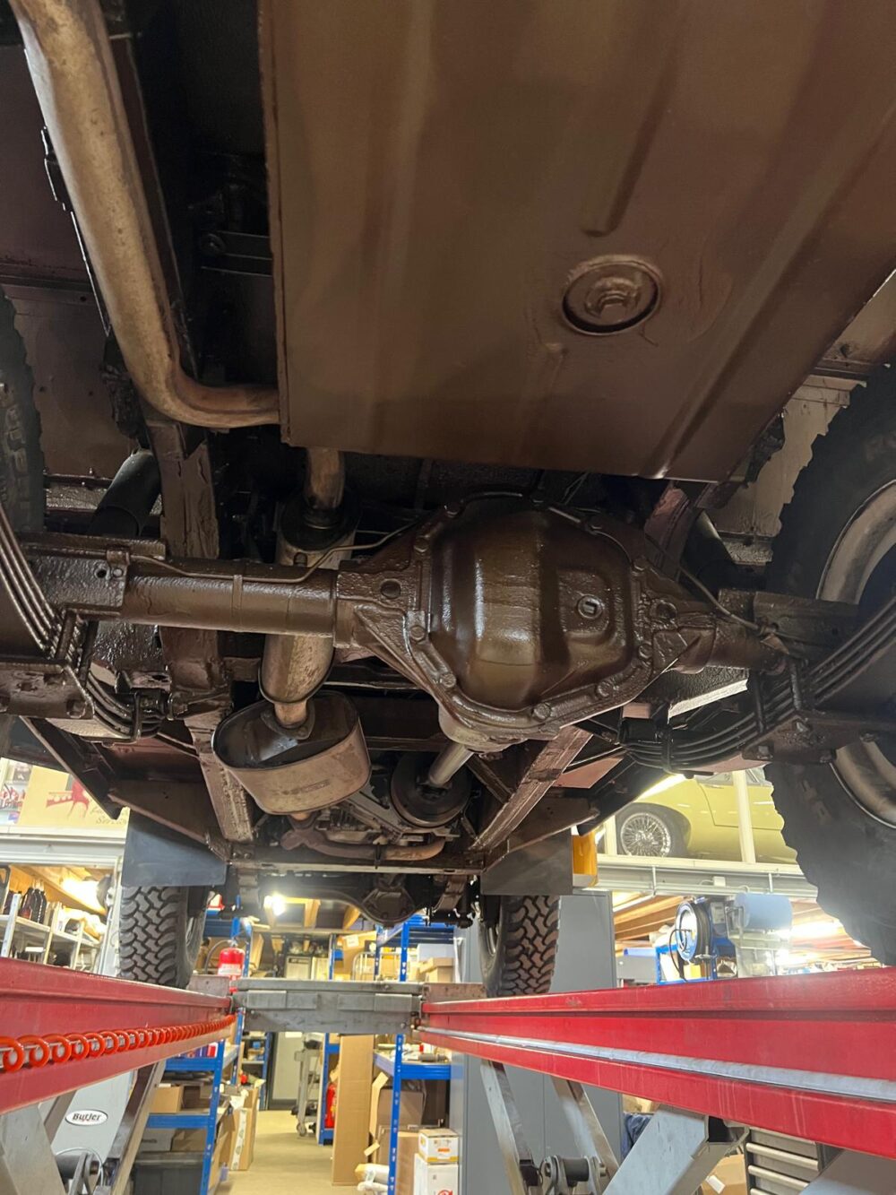 Vehicle underside on lift showing differential and chassis