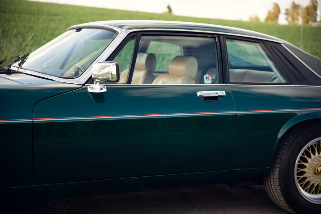 Green vintage car with beige interior parked outdoors