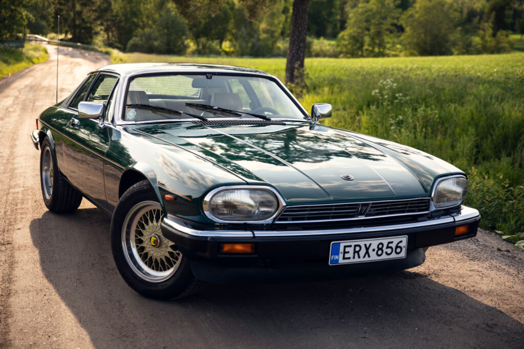 Vintage green sports car on a sunlit rural road