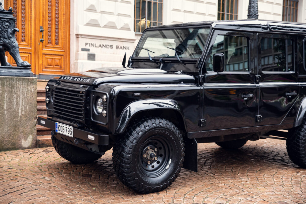 Black Land Rover Defender parked outside historic building