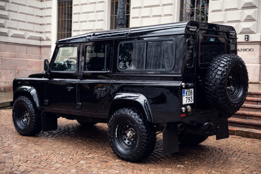 Black Land Rover Defender parked on cobblestone street