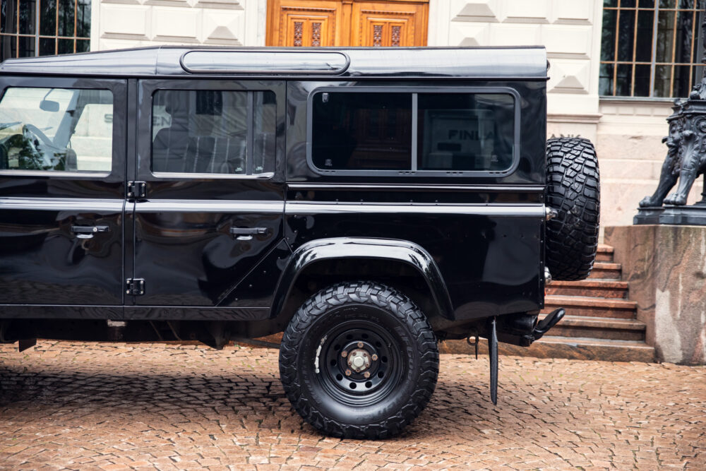 Black rugged SUV parked on cobblestone street
