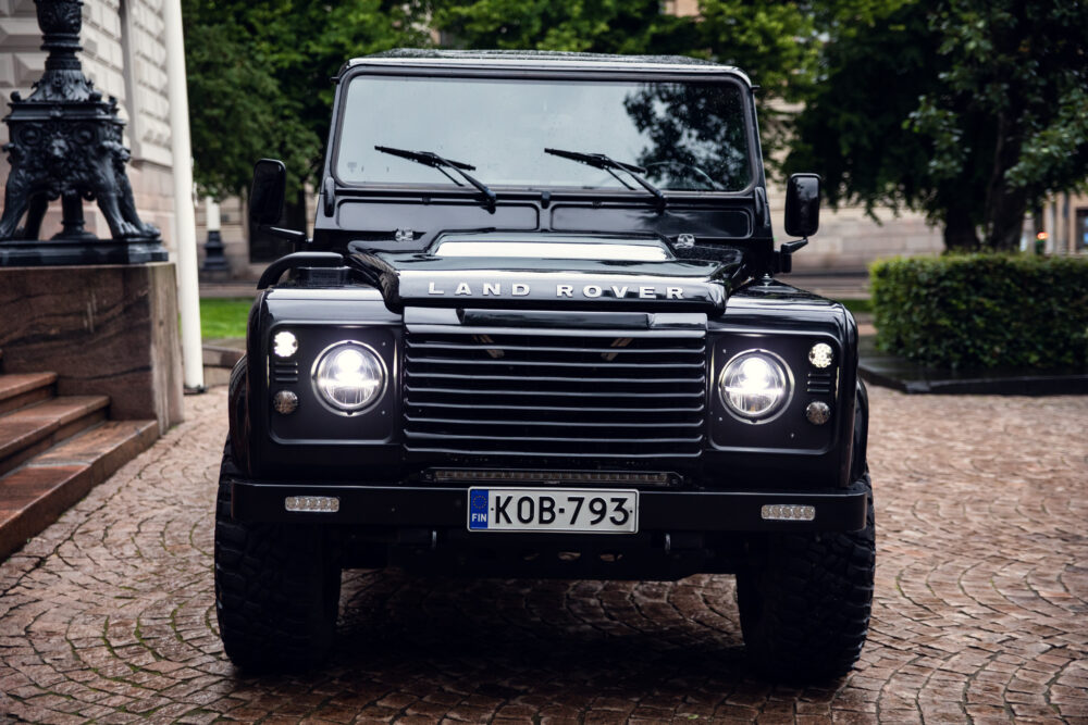Black Land Rover Defender parked on cobblestone street