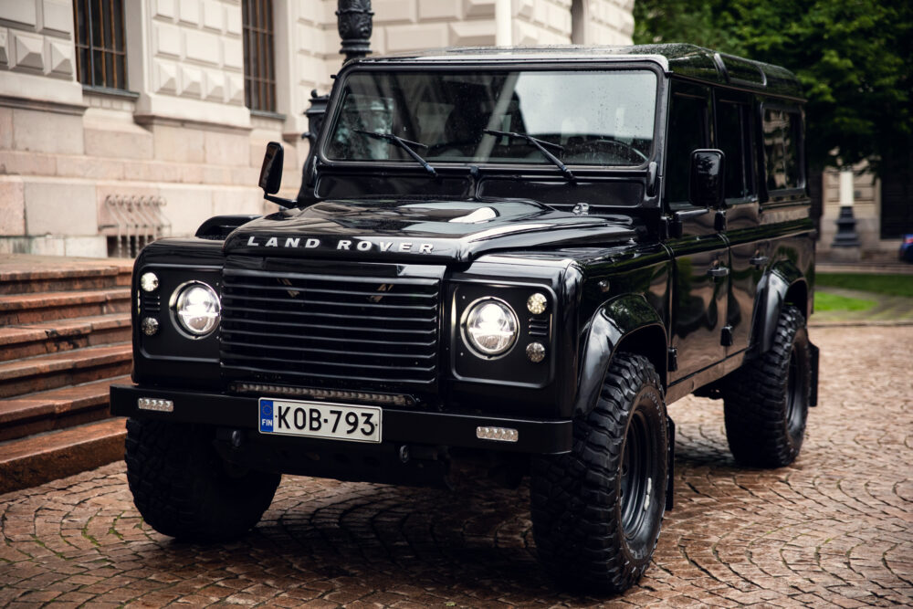 Black Land Rover Defender parked on cobblestone street