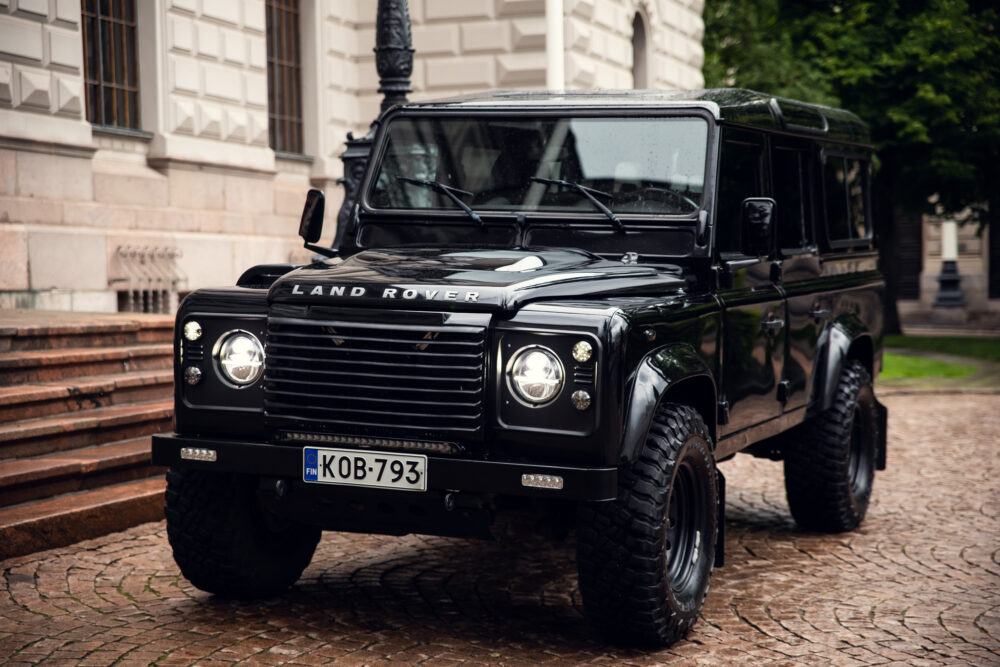 Black Land Rover Defender parked by European building