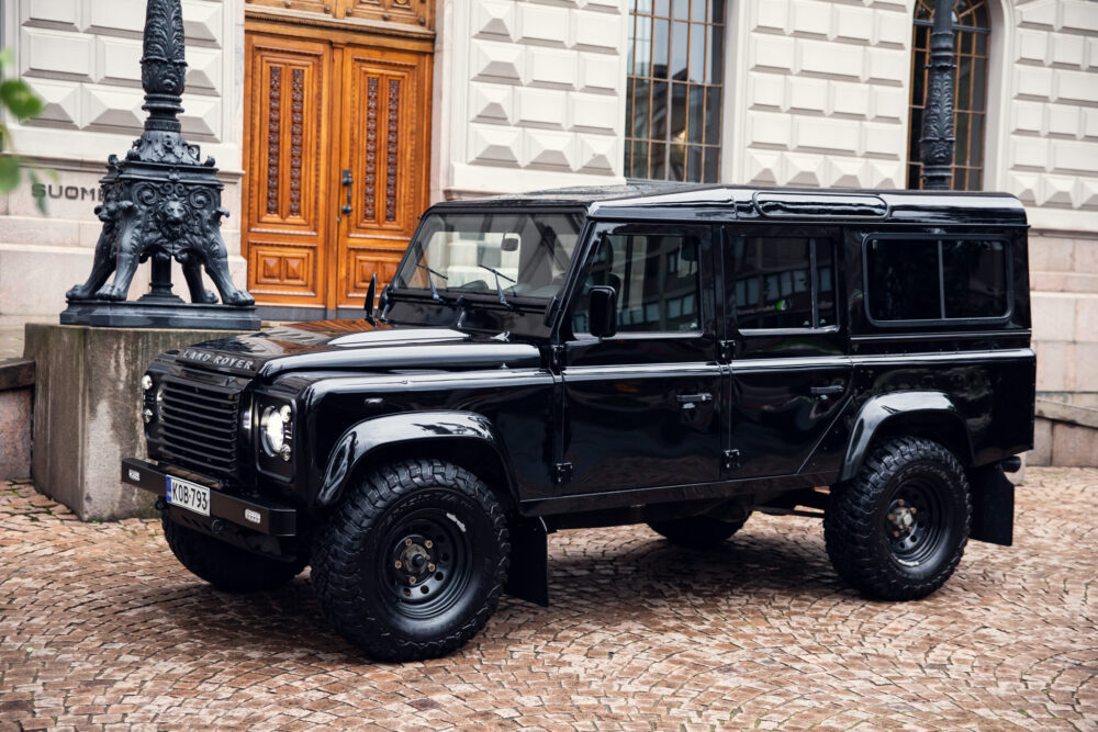 Black Land Rover Defender parked near ornate building