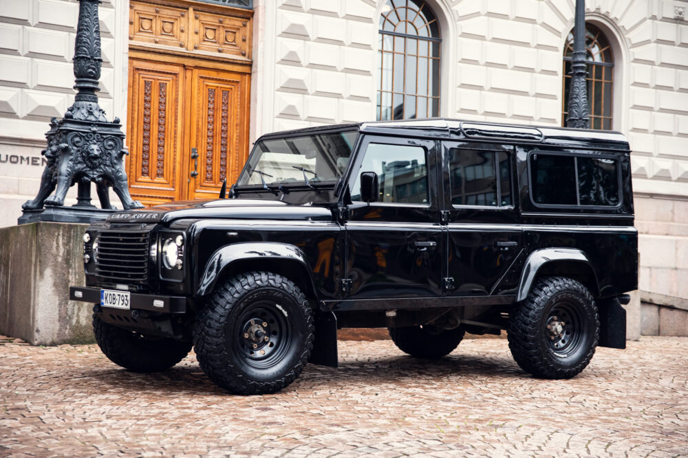 Black Land Rover Defender parked on cobblestone street