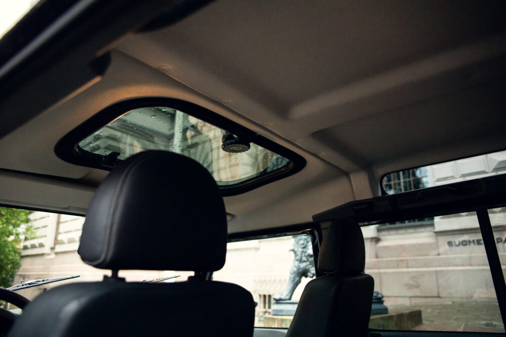 View from inside car showing rainy window and statue