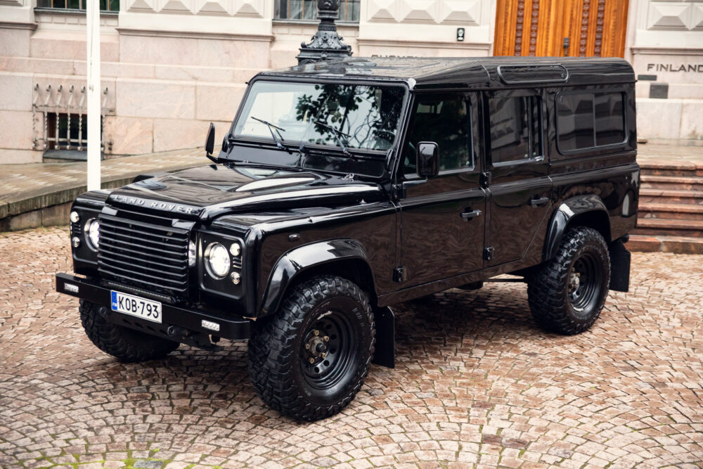 Black Land Rover Defender parked on cobblestone street