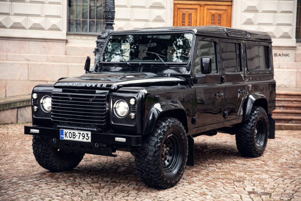 Black Land Rover Defender parked by building