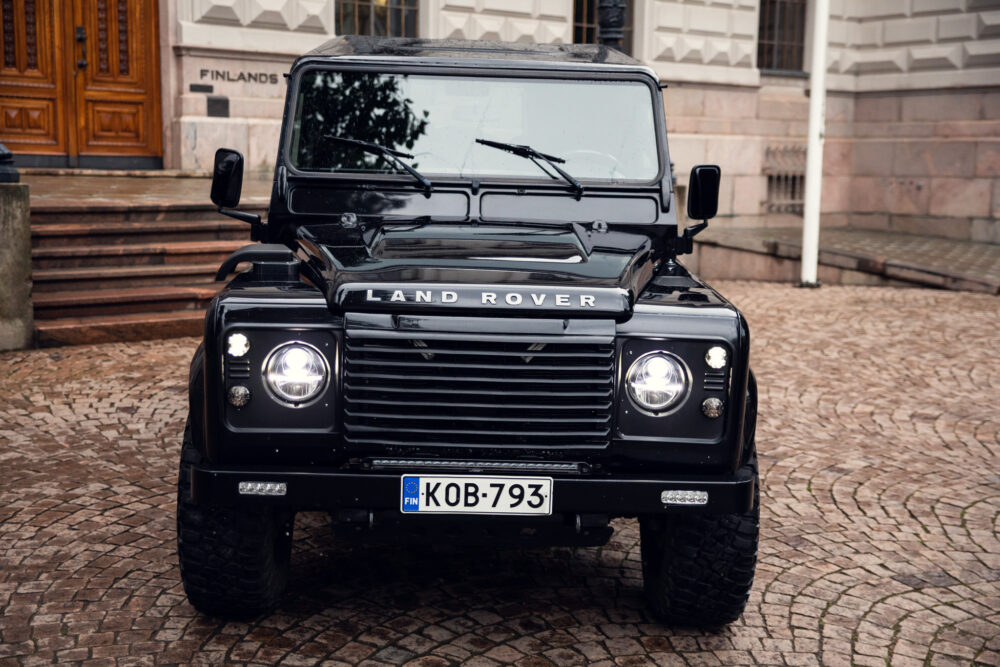 Black Land Rover Defender parked in front of building