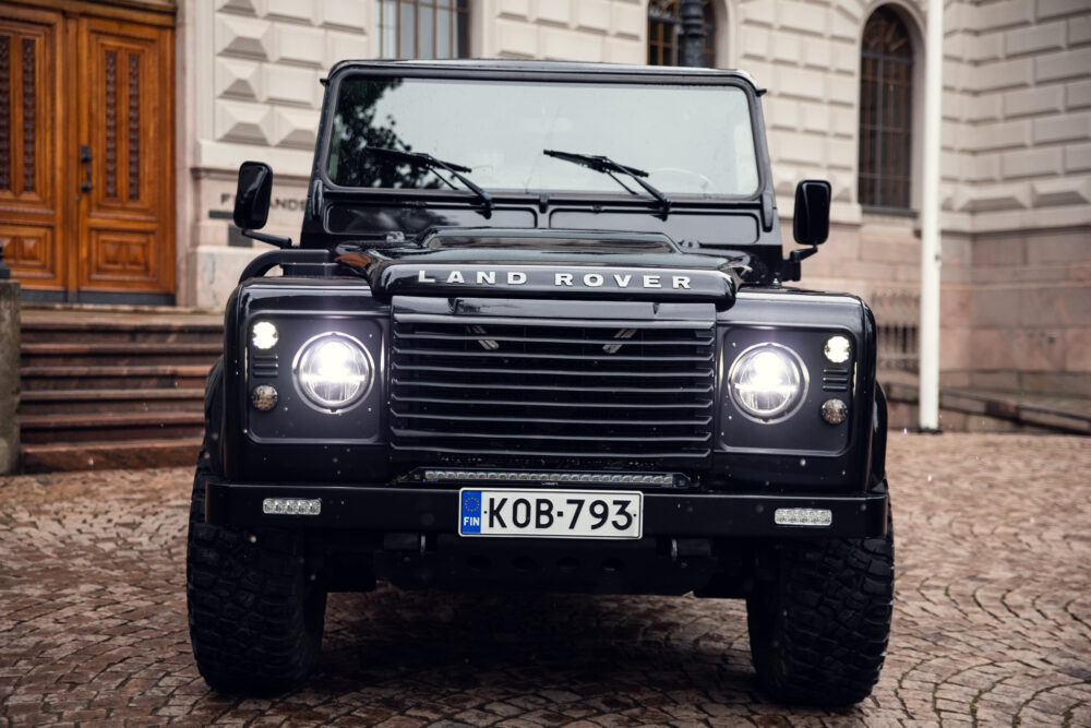 Black Land Rover Defender parked in front of building