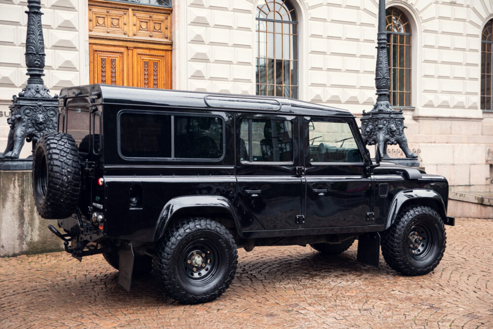 Black Land Rover Defender parked near ornate building