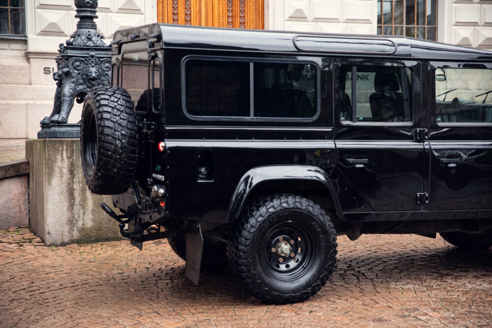 Black SUV with spare tire parked near ornate lamp post