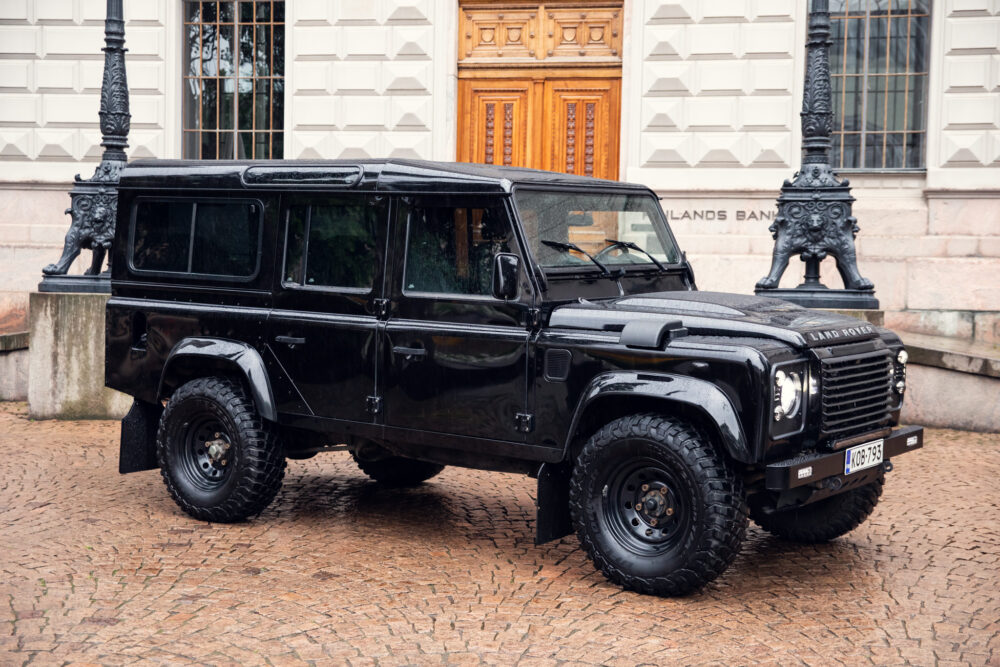 Black Land Rover Defender parked on cobblestone street