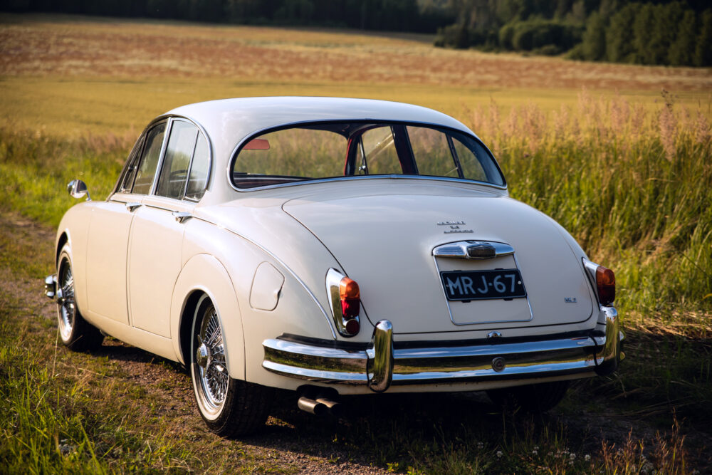 Vintage white car parked in a grassy field
