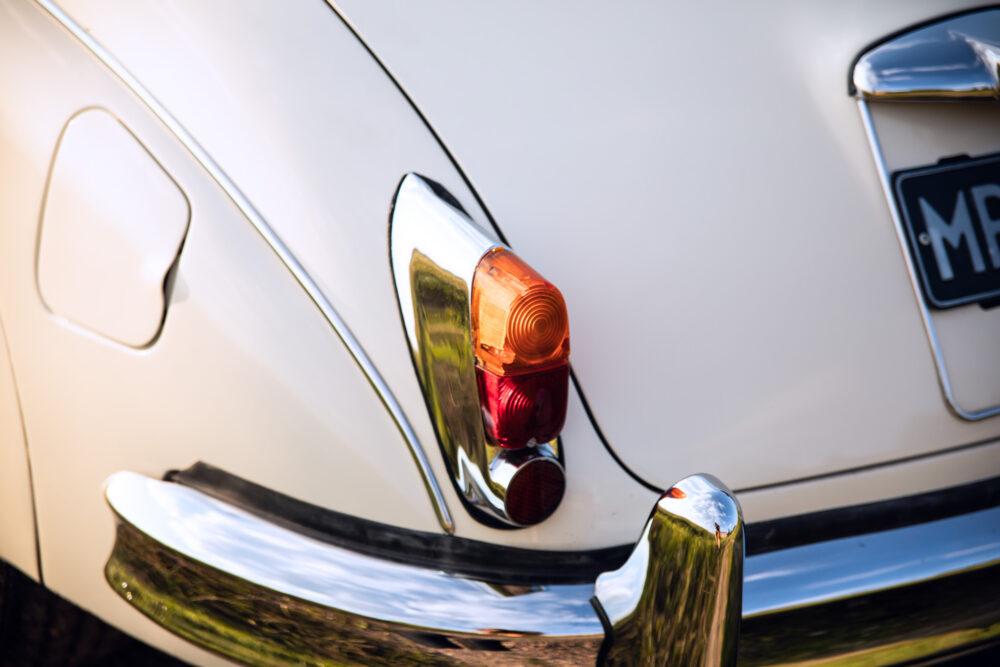 Vintage car tail light close-up, shiny chrome bumper