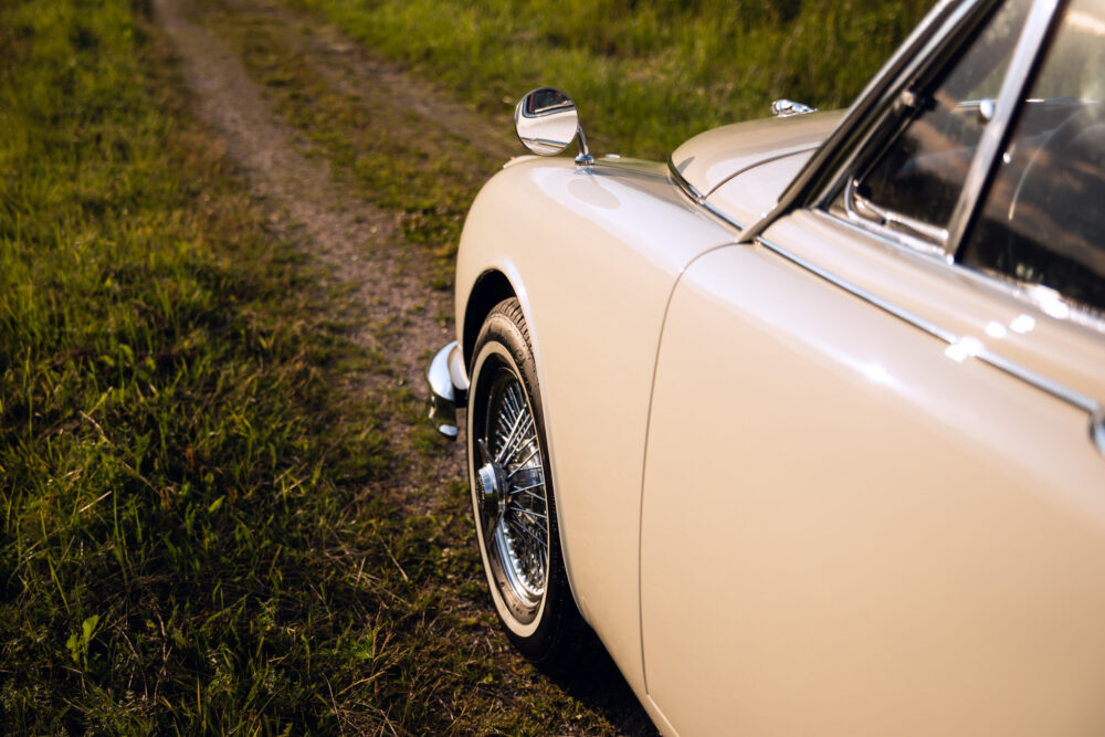 Vintage cream car parked on grassy country road