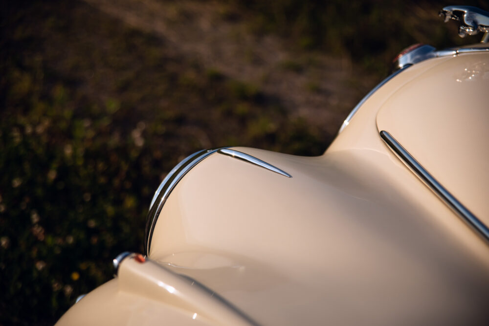 Close-up of vintage car's beige hood and chrome details