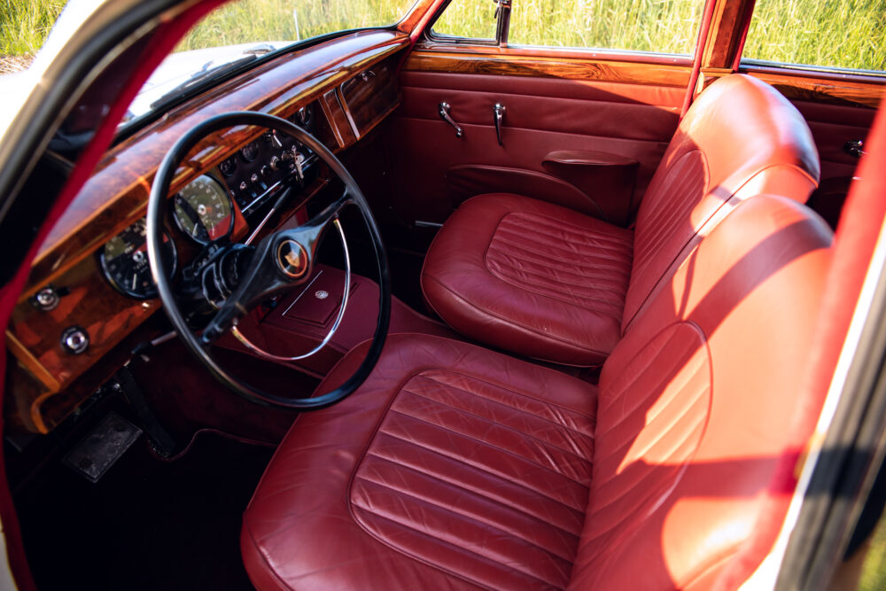 Vintage car interior with red leather seats and wooden dashboard