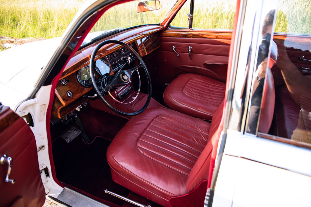 Vintage car interior with luxurious red leather seats.