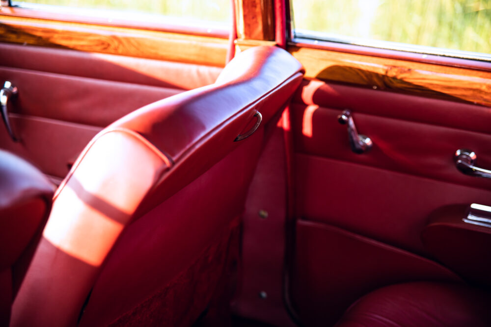 Vintage car red leather interior with sunlit details