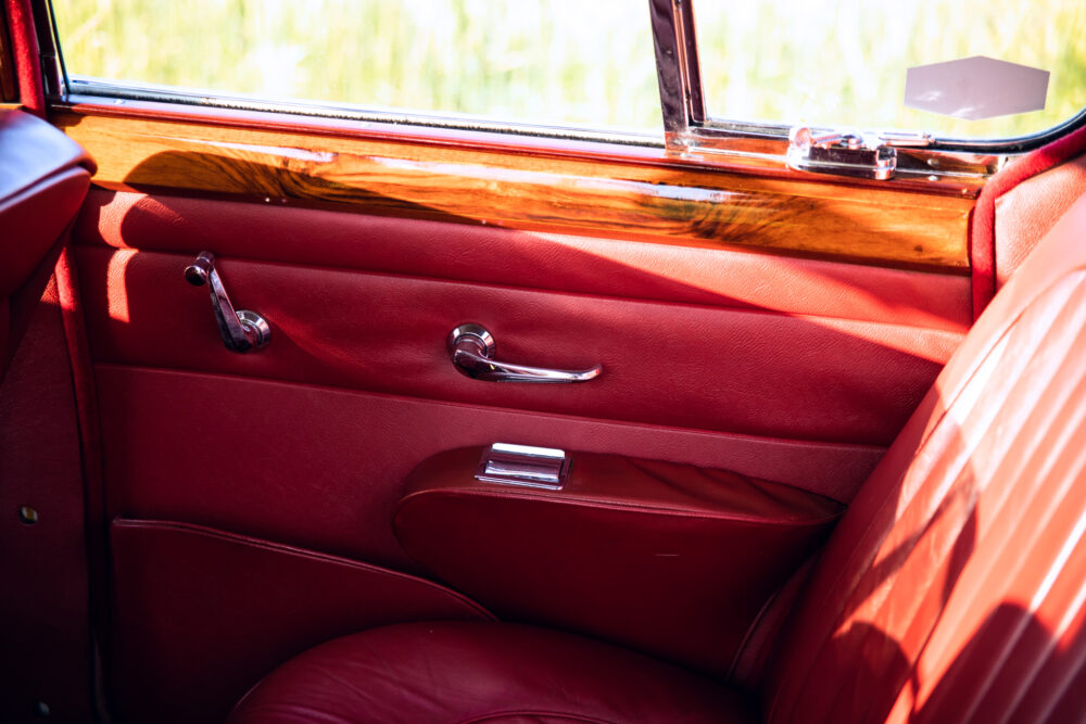 Vintage car's red leather interior with wood trim