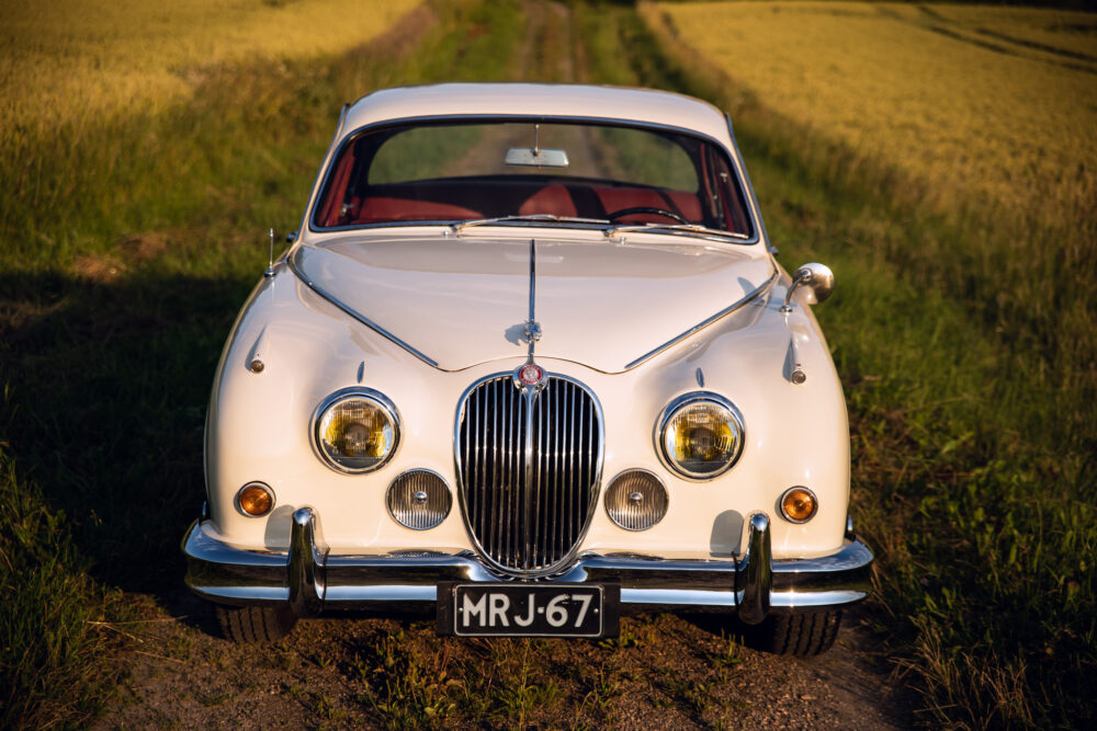 Vintage white Jaguar car on countryside road
