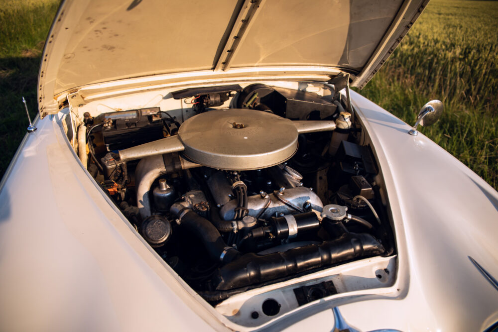 Vintage car engine open in grassy field