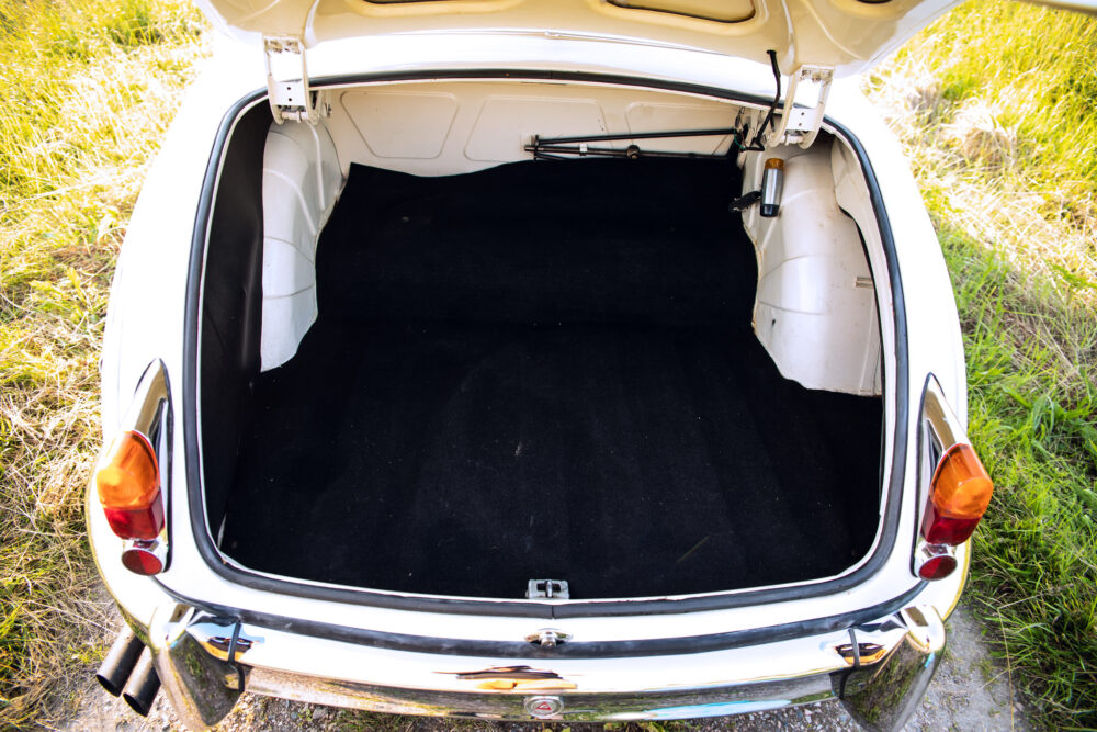 Open trunk of vintage white car with black interior