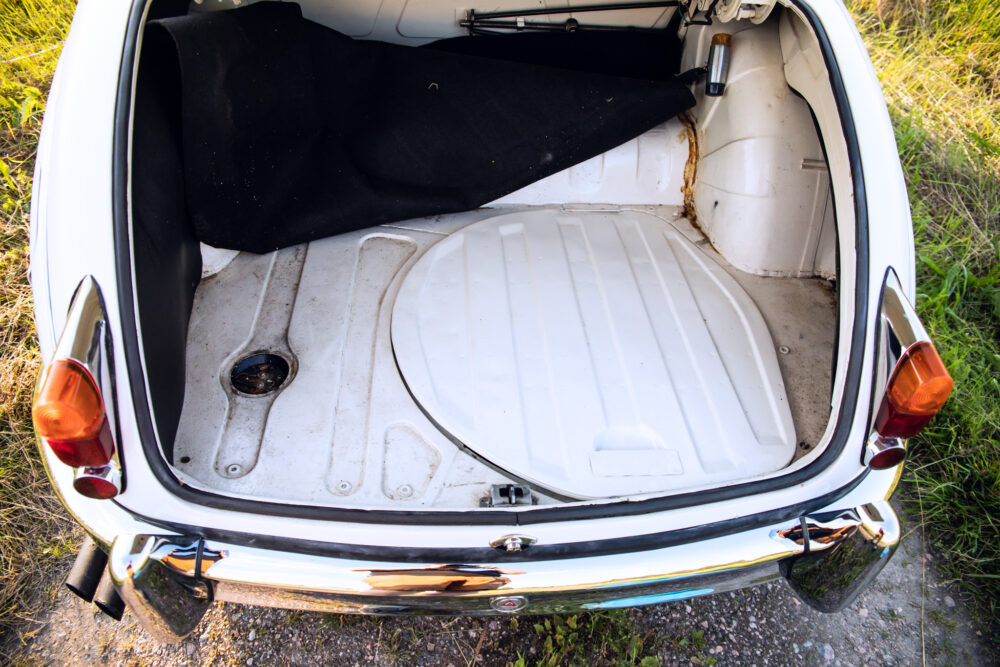 Open trunk of vintage car showing spare wheel well