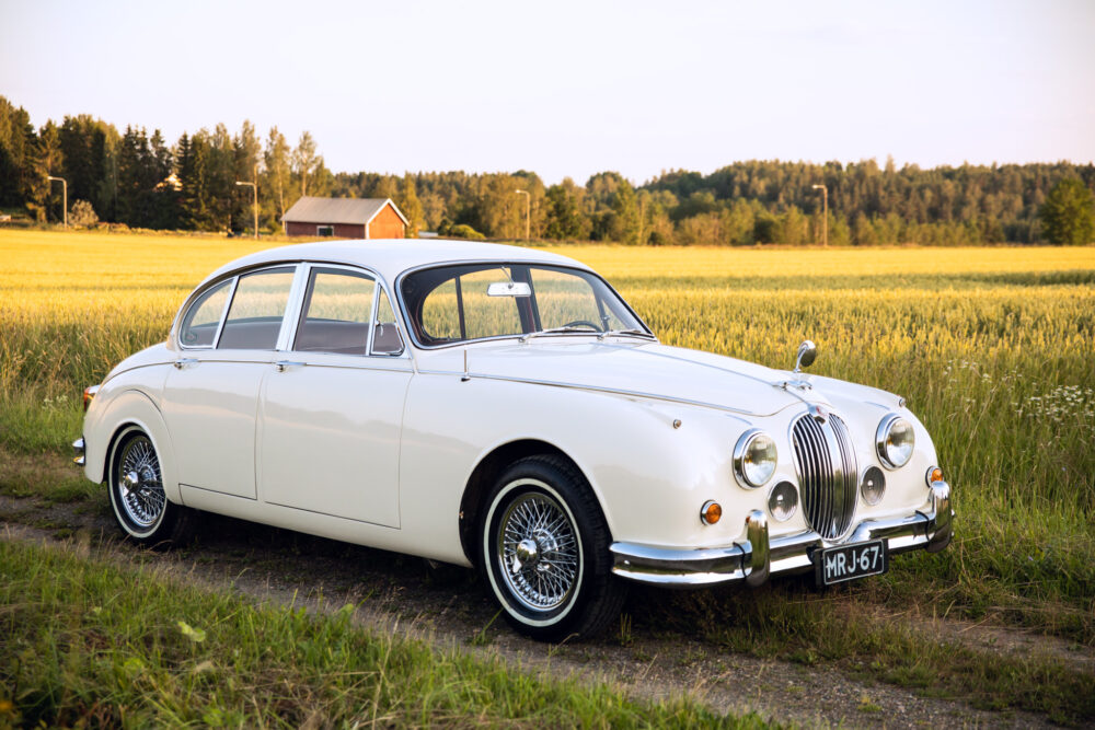 Vintage white Jaguar car in rural setting