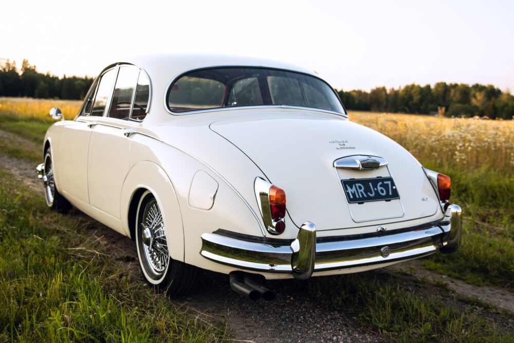 Classic white Jaguar sedan in scenic countryside