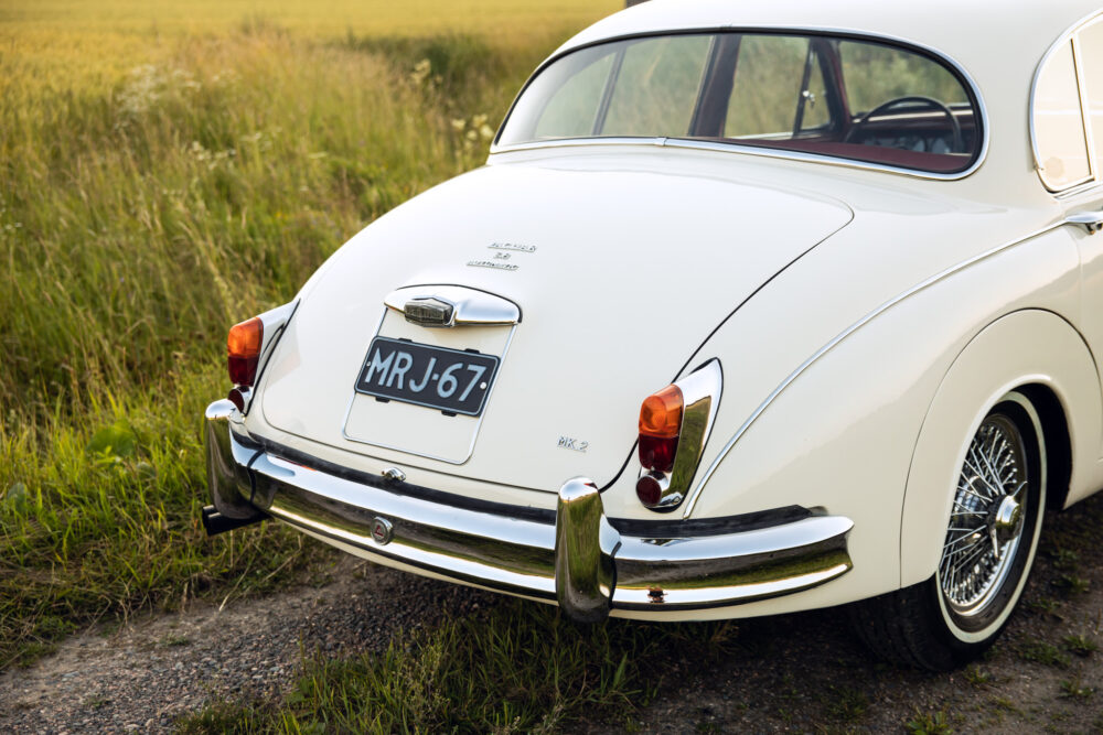 Vintage white Jaguar Mk2 car on grassy field