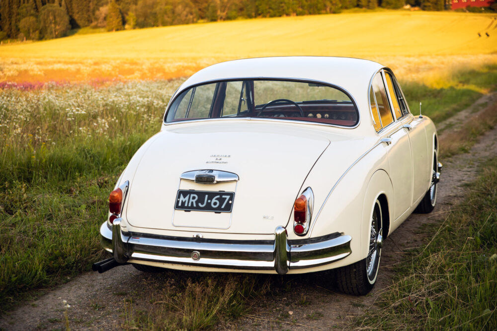 Vintage white Jaguar car in scenic countryside