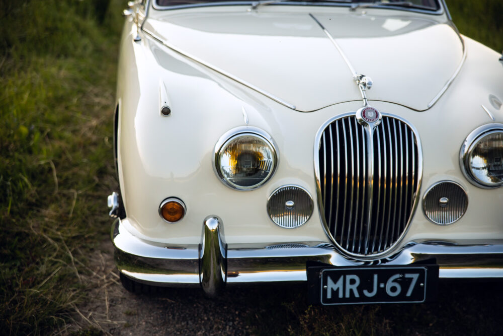 Vintage white Jaguar car front view on grass