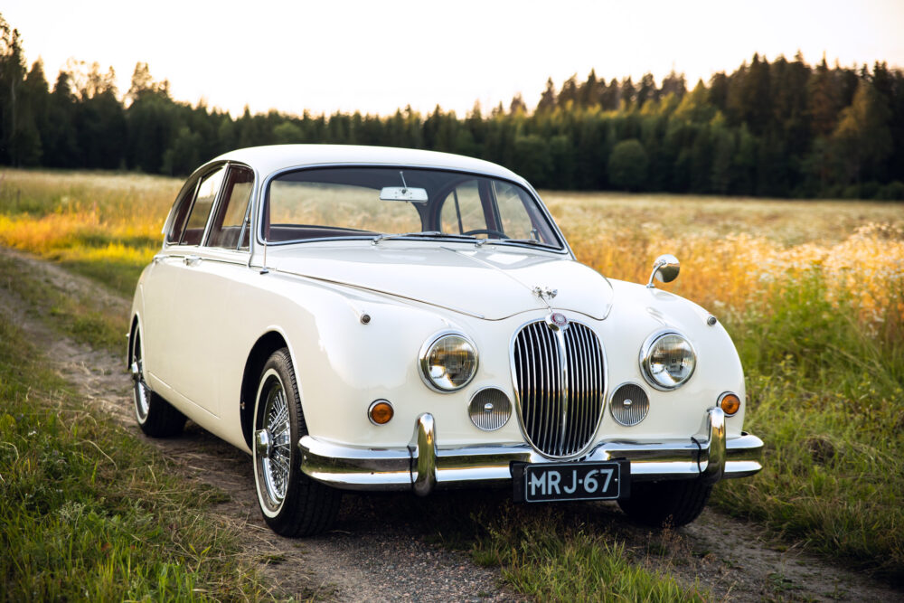 Vintage white Jaguar car in sunlit field