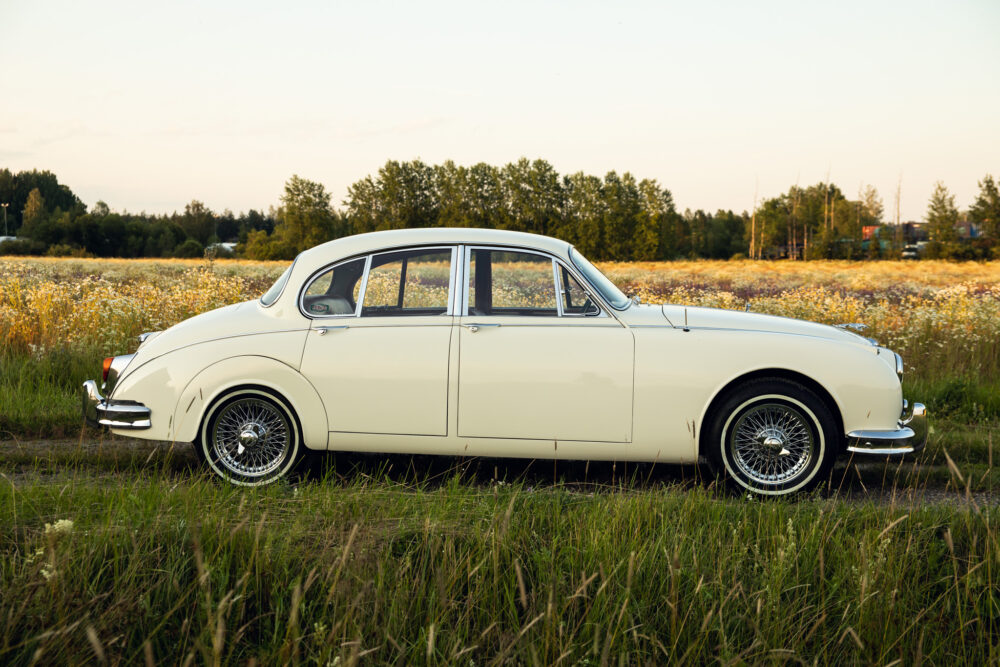 Vintage white car parked in a wildflower field