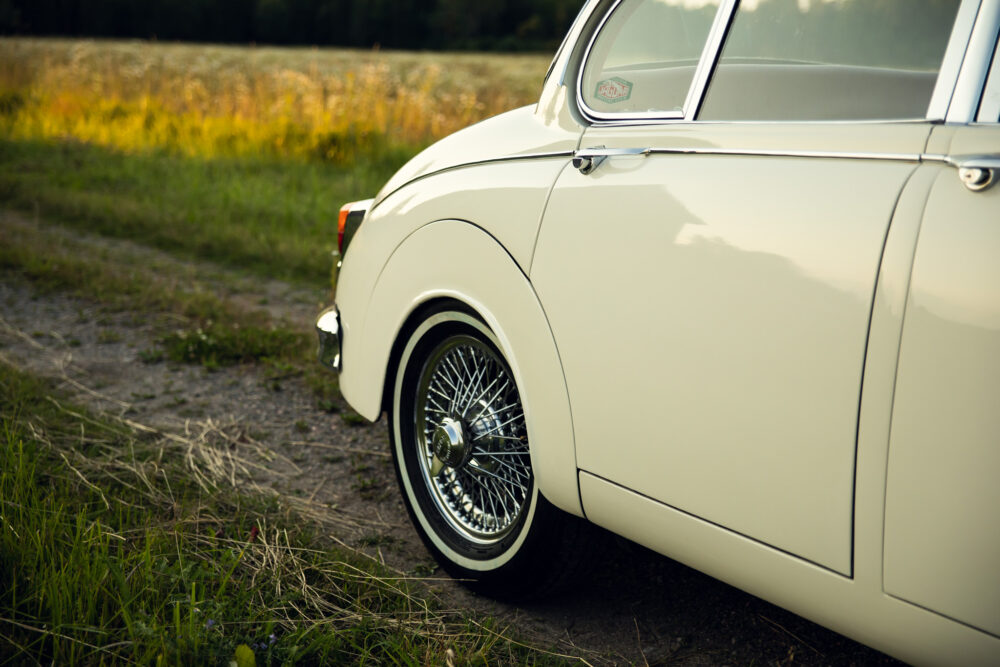 Classic white car with chrome wheels in natural setting