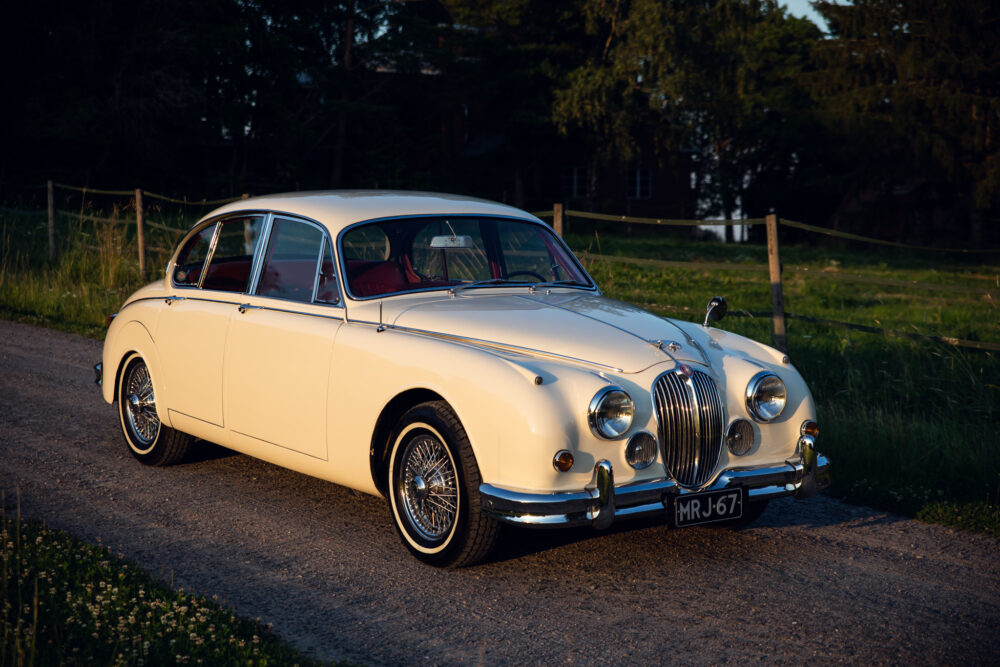 Vintage cream Jaguar car parked outdoors at sunset