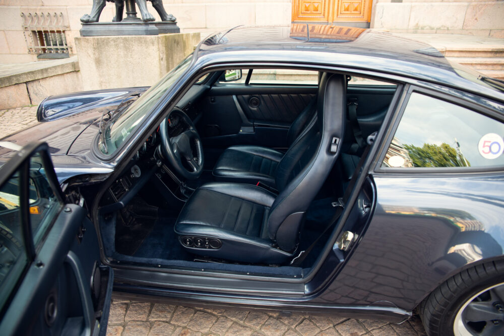 Classic car interior, open door, black leather seats