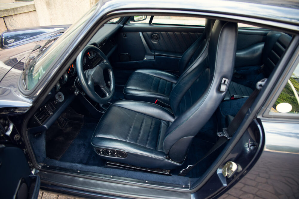 Black classic car interior, leather seats and dashboard.