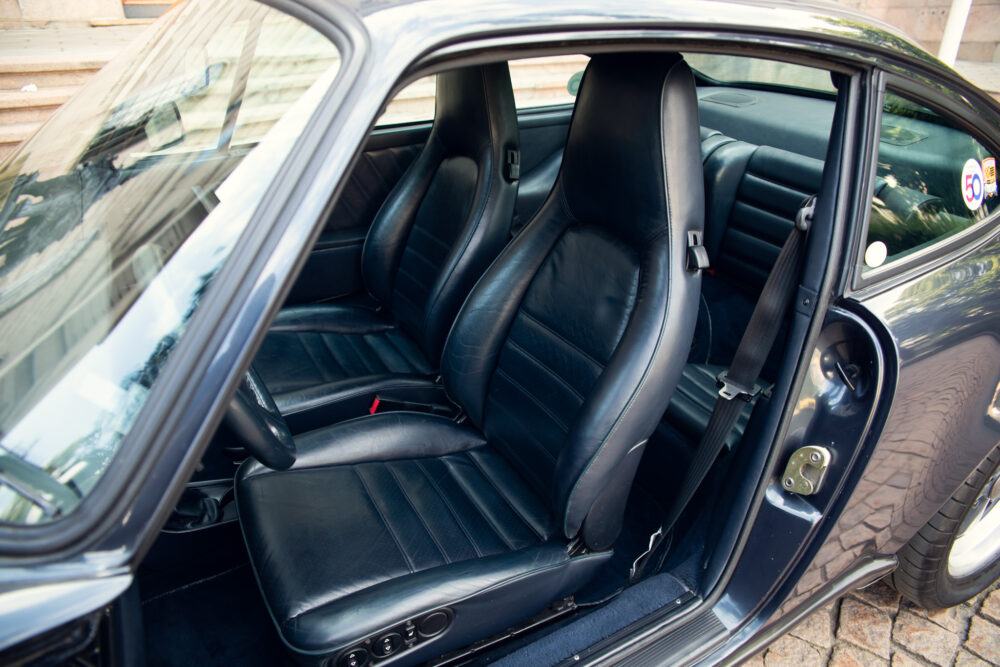 Open car door showing black leather interior seats