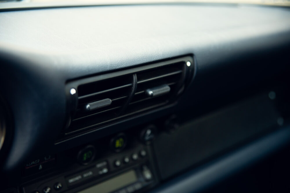 Close-up of car dashboard with air vents and controls