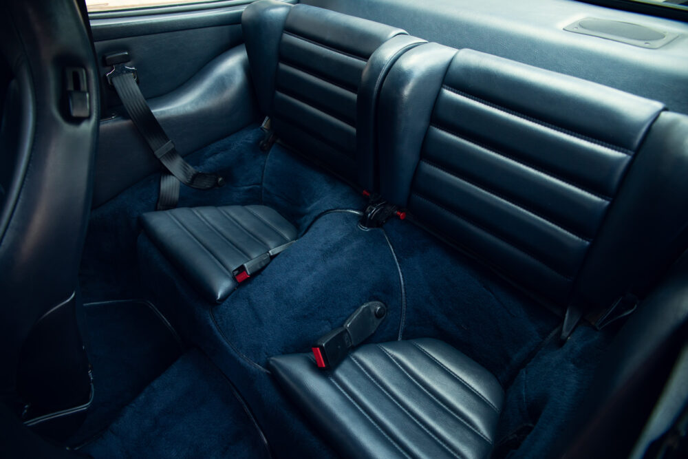Dark leather car interior with blue carpet
