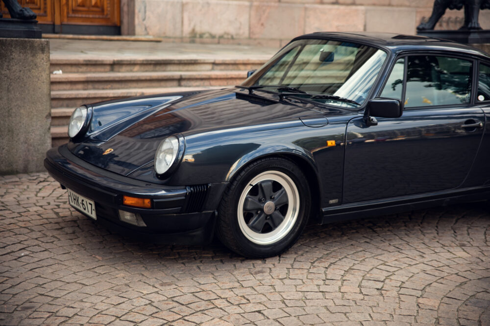 Vintage black Porsche parked on cobblestone street