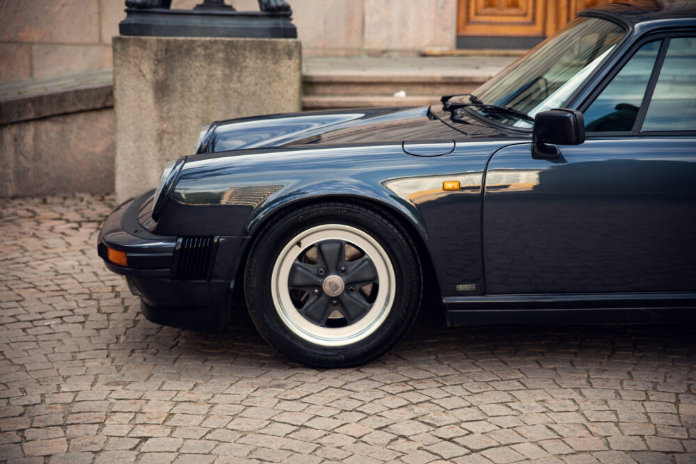 Classic black sports car parked on cobblestone street