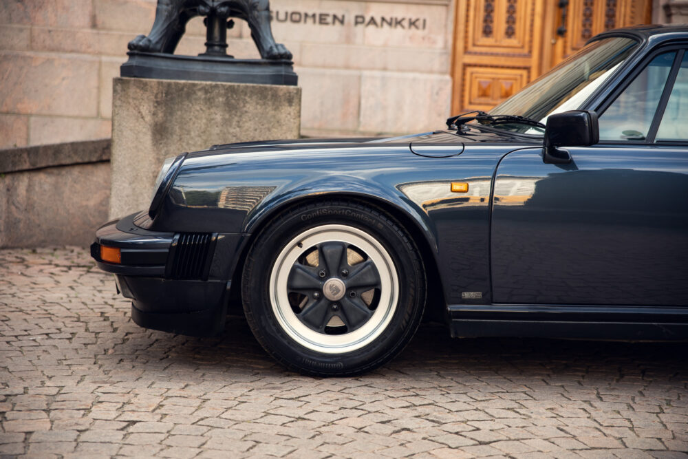 Vintage black Porsche near historic building facade