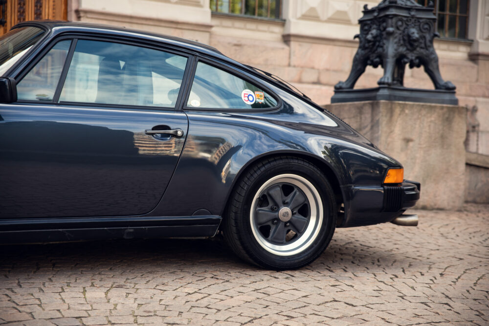 Vintage black Porsche 911 on cobblestone street
