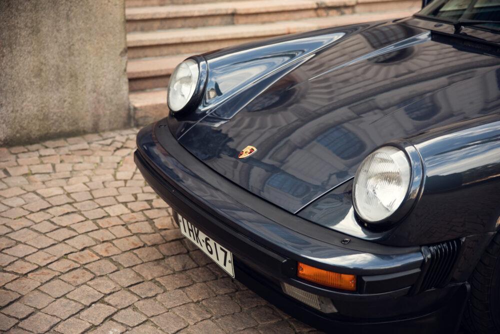 Black Porsche 911 classic car on cobblestone street